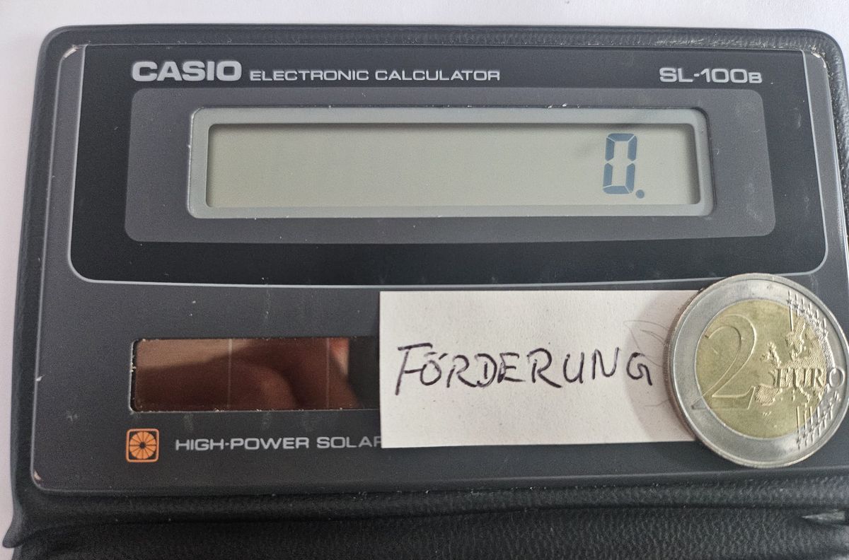 Taschenrechner mit Notiz Förderung und 2-Euro-Münze